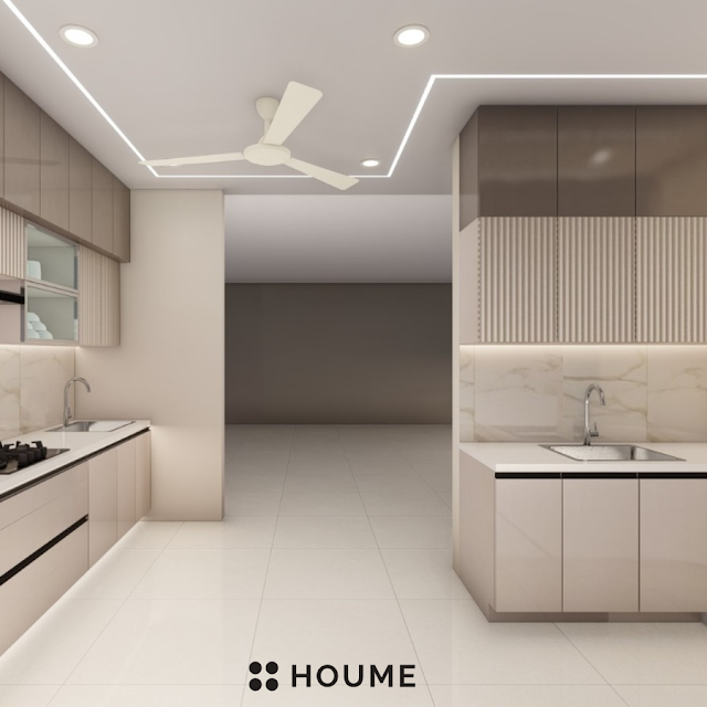 Modern kitchen with a black stainless steel stovetop, oven, and vent hood, light wood cabinets, and white quartz countertops. A ceiling fan with woven blades hangs from the vaulted ceiling with exposed wooden beams. Text overlay: Houme India - Kitchen Design Ideas. C