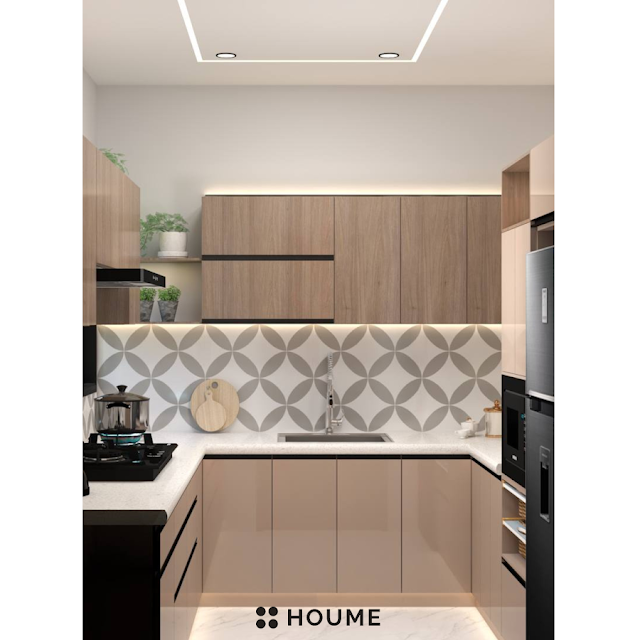 Kitchen with a stainless steel stove and a black pot on the burner. A window with a black metal frame is above the stove, and a white patterned tile backsplash can be seen behind the stove. Text overlay: Houme India - Kitchen Design Ideas. C