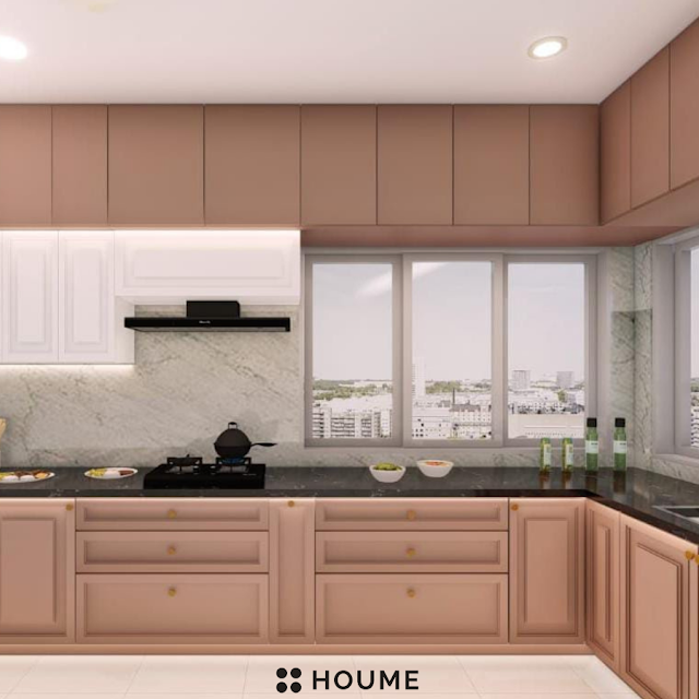 Kitchen with vaulted ceiling featuring exposed wooden beams and a large arched window with a black metal frame. The kitchen has white cabinets, a farmhouse sink with a vintage faucet, and a black pendant lamp. Text overlay: Houme India - Kitchen Design Ideas. B
