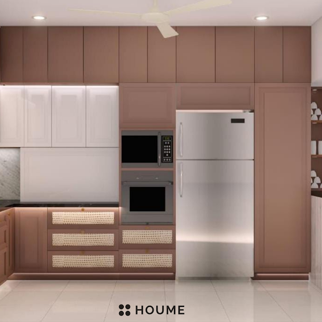 Kitchen with vaulted ceiling featuring exposed wooden beams and a large arched window with a black metal frame. The kitchen has white cabinets, a farmhouse sink with a vintage faucet, and a black pendant lamp. Text overlay: Houme India - Kitchen Design Ideas. D