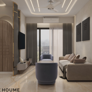 Living room featuring a large leaning mirror with a brushed gold metal frame, a round jute rug in a light natural color, and a white boucle armchair with a curved wooden frame. Text overlay: Houme India - Interior Design Ideas. C