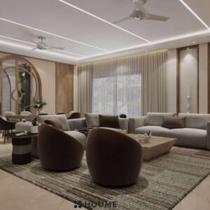 Living room featuring a ceiling fan with woven blades hanging from the ceiling. A brown leather couch sits on a woven jute rug. Two brown accent chairs flank a round wooden coffee table with a black metal base. Text overlay: Houme India - Interior Design Ideas. C