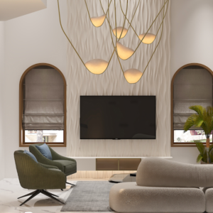Living room with a modern gray couch, round wood coffee table with black metal legs, and a woven jute rug. Text overlay: Houme India - Interior Design Ideas. C