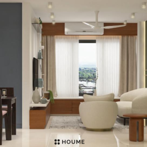 Living room featuring a mid-century modern olive green fabric sofa with a tufted back and tapered wooden legs. A round wood coffee table with splayed legs sits on a cream colored area rug. Text overlay: Houme India - Interior Design Ideas. B