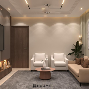 Living room featuring a mid-century modern olive green fabric couch, round wood coffee table with splayed legs, and a cream colored area rug. Text overlay: Houme India - Interior Design Ideas. B