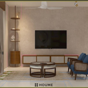 Living room with a ceiling fan with woven blades hanging from the ceiling. A brown leather couch sits on a woven jute rug. Two brown accent chairs flank a round wooden coffee table. Text overlay: Houme India - Interior Design Ideas. B