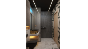 Simple, clean bathroom interior featuring a white toilet, pedestal sink with a chrome faucet, and a rectangular mirror with a chrome frame above the sink. The walls are a light beige color, and a window with frosted glass on the right wall allows for natural light to fill the room while maintaining privacy. Text overlay: Houme India - Interior Design Ideas. B