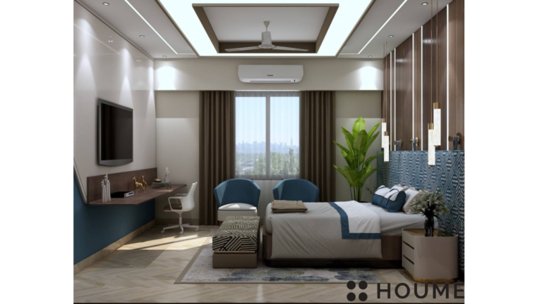 Bedroom interior featuring a king-size bed with a dark wood headboard and white bedding. A white nightstand with a lamp sits on the left side of the bed. There is a window with white blinds on the left wall. Text overlay: Houme India - Interior Design Ideas. B
