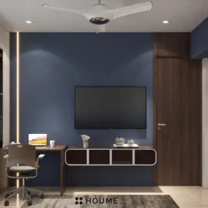 Cozy guest bedroom interior featuring a blue daybed with a white comforter and pillows. A nightstand with a lamp sits beside the daybed. A ceiling fan hangs from the ceiling. Text overlay: Houme India - Interior Design Ideas. C