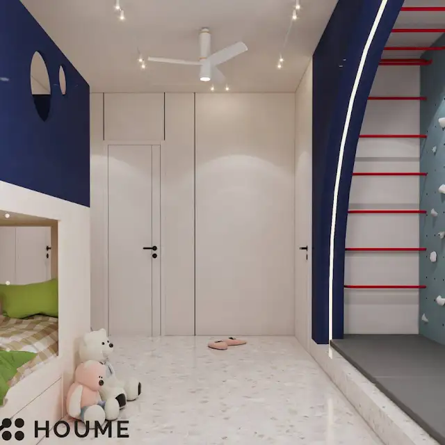 Children's bedroom interior featuring a climbing wall with colorful handholds in various shapes and sizes. The climbing wall covers one wall of the bedroom. Text overlay: Houme India - Interior Design Ideas. B