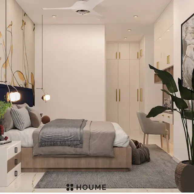Children's bedroom interior featuring a colorful mural of a giraffe on the accent wall. A mid-century modern style bed with a woven cream blanket and pillows sits in front of the mural. A round wooden nightstand with a drawer is placed beside the bed. Text overlay: Houme India - Interior Design Ideas. B