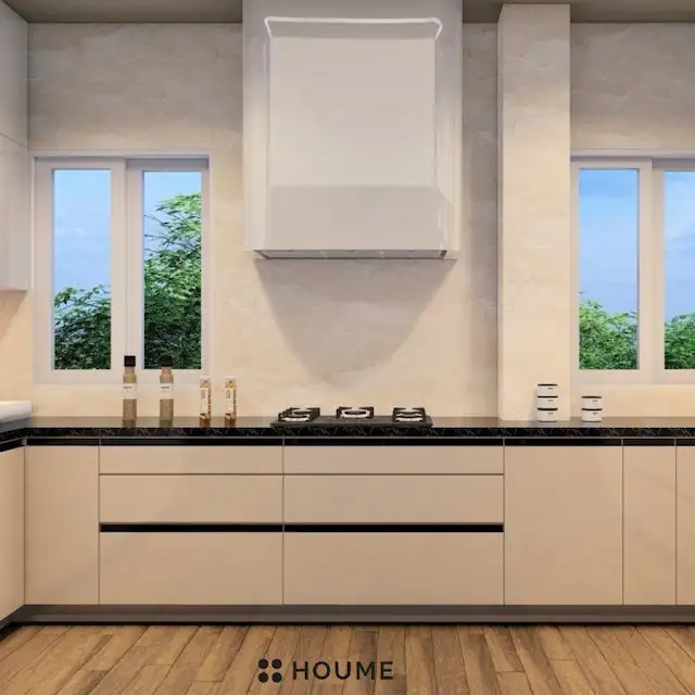 Modern kitchen interior featuring white cabinets with chrome hardware and a built-in microwave oven above the counter. A stainless steel sink and faucet are visible in the foreground. Text overlay: Houme India - Interior Design Ideas. B