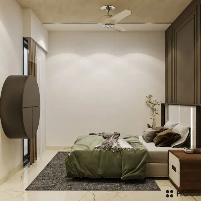 Mid-century modern bedroom interior with a low profile platform bed in walnut wood with a woven cream blanket and pillows. A round wooden nightstand with a single drawer sits beside the bed. A woven jute rug in a light natural color covers the floor. Text overlay: Houme India - Interior Design Ideas. C