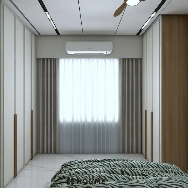 Mid-century modern bedroom featuring a platform bed with a walnut wood frame, a woven cream blanket and pillows, and a round wooden nightstand with a drawer. A woven jute rug covers the floor. A ceiling fan with woven blades hangs from the ceiling. Text overlay: Houme India - Interior Design Ideas. C