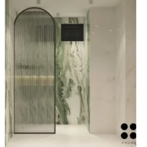 Modern bathroom interior featuring a freestanding bathtub positioned in the center of the room, with a large window behind it offering a view of a garden. The bathtub has a chrome faucet and sits on a white tile floor. Text overlay: Houme India - Interior Design Ideas. B