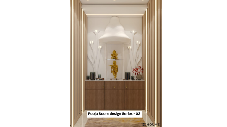 A close-up photo of a modern pooja room design. The pooja unit has a sleek, white marble finish with clean lines and gold hardware accents. The unit features a shelf with a backlit panel displaying Hindu deities. Offerings and prayer items are placed on the shelf.