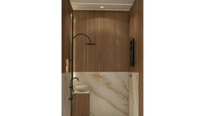 A modern washroom design with a luxurious feel, featuring a wood-paneled wall, marble accents, a unique oval mirror, floating vanity, and a rainfall showerhead. C