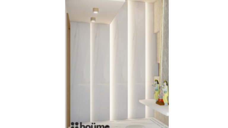 A modern minimalist pooja room with a textured marble wall, recessed lighting, idols of deities, and floor cushions. B