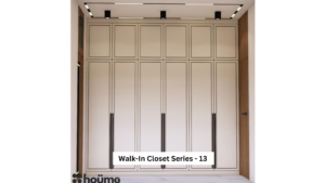 A digitally rendered image of a spacious walk-in closet featuring white wardrobes with long black handles and recessed lighting. A