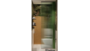 A modern washroom by Houme India with a vibrant green tropical wallpaper on one wall and light brown tiles on the others. B