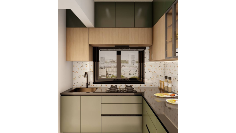 A contemporary L-shaped kitchen with dark green cabinets, wood upper cabinets with glass doors, and a speckled backsplash. The countertop is a dark material, and various dishes are placed on it. C