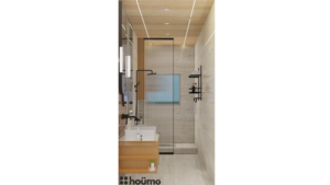 A modern washroom by Houme India with light wood accents, a glass-enclosed shower, a rectangular mirror with an illuminated border, and a white sink. C