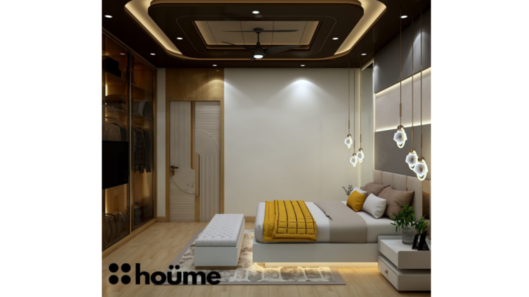 A modern master bedroom by Houme India with a dark recessed ceiling, a gray textured accent wall, and three modern pendant lights hanging above the bed. B