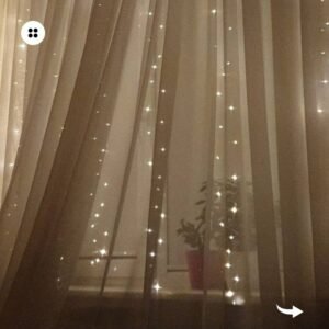 Sheer curtains with delicate string lights create a dreamy and romantic atmosphere in a bedroom.