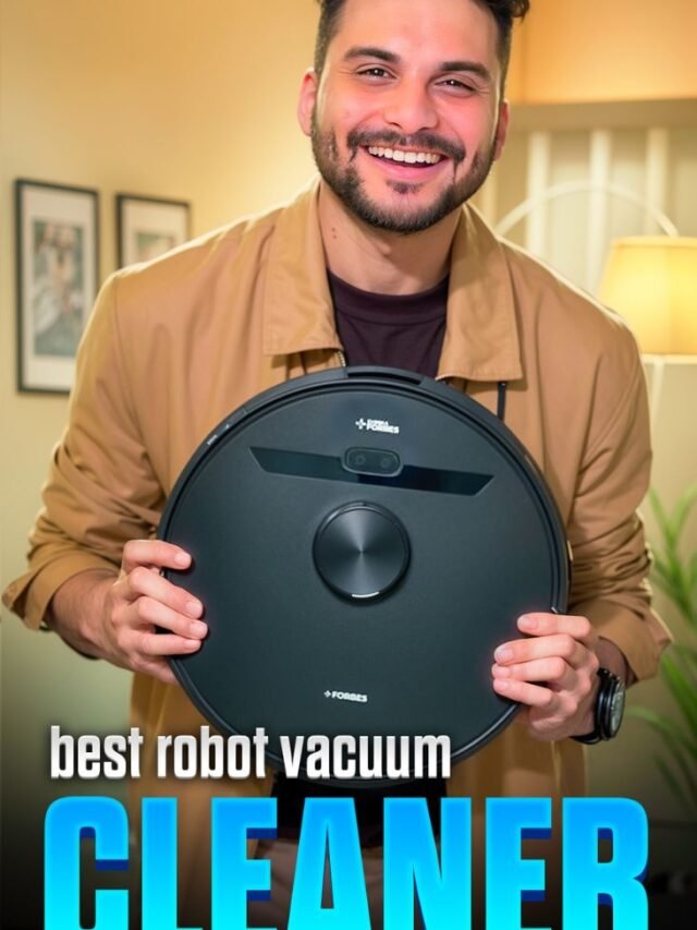 A smiling reviewer holding a black Forbes robot vacuum cleaner, representing a guide to the best robot vacuums in India for 2025.