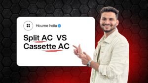 A smiling man in a light jacket pointing towards a bold text graphic that reads "Split AC vs Cassette AC" under the Houme India brand logo