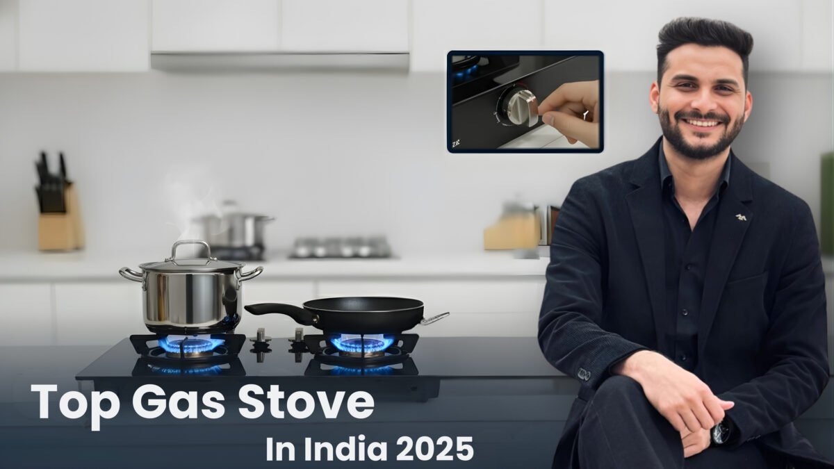 A sleek, black glass-top gas stove with two burners showing blue flames, cooking a stainless steel pot and a frying pan. The stove is set into a modern white kitchen counter. A man (Sourabh) in a black suit smiles and gestures towards the stove. An inset image shows a hand operating one of the stove's control knobs. The title "Top Gas Stove In India 2025" is displayed at the bottom.