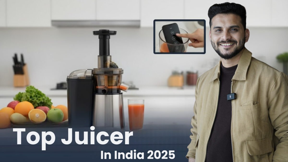 A modern slow masticating juicer in black and silver sits on a kitchen counter, surrounded by fresh fruits and vegetables (oranges, apples, leafy greens). A glass of freshly made juice is next to the juicer. A confident man (Sourabh) in a black suit gestures towards the juicer, with an inset image showing a hand operating the juicer's controls. The title "Top Juicer In India 2025" is displayed at the bottom against a blurred modern kitchen background.