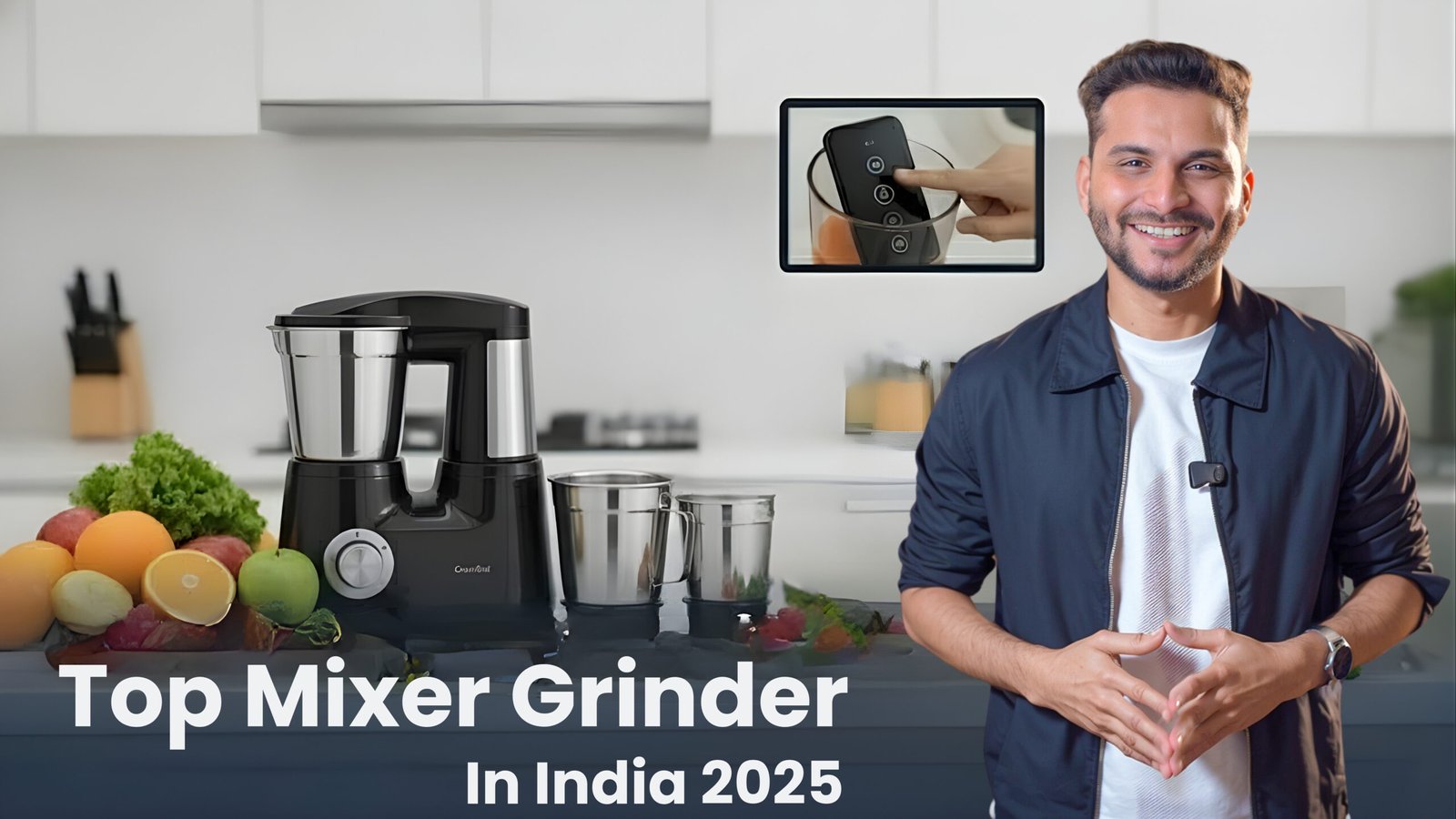 A sleek black and silver mixer grinder with multiple steel jars positioned on a modern kitchen counter, surrounded by fresh fruits and vegetables. A confident man (Sourabh) in a black suit smiles and gestures towards the appliance. An inset image shows a hand operating a smart control panel or a remote control for the mixer grinder. The title "Top Mixer Grinder In India 2025" is displayed at the bottom, against a blurred, contemporary kitchen background.